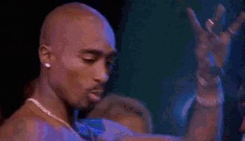 a close up of a man without a shirt on a stage in a dark room .