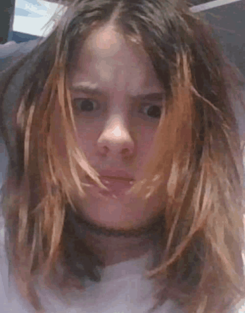 a girl with long hair and a choker making a face