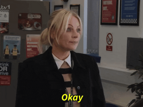 a woman says okay in front of a fridge