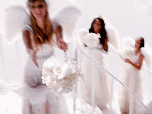 a blurry photo of three women in white dresses