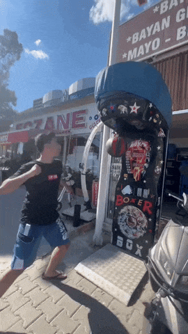 a man is throwing a punch in front of a boxer box machine