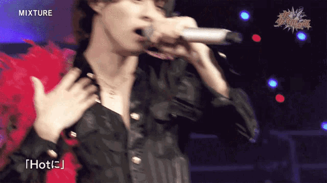 a man singing into a microphone with the word mixture on the bottom right