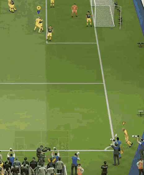 a group of soccer players are playing on a field with a yellow triangle in the center