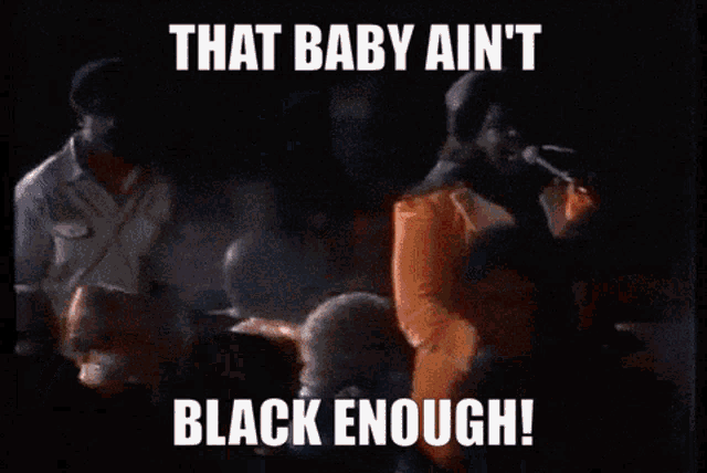 a man in a suit stands on a stage with the words that baby ain t black enough