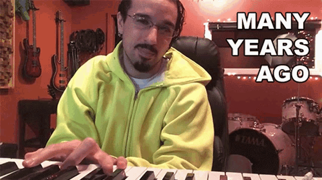 a man playing a keyboard with the words many years ago written above him