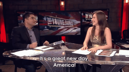 a man and a woman are sitting at a table with the words " it 's a great new day america "