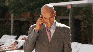 a man in a suit is talking on a cell phone