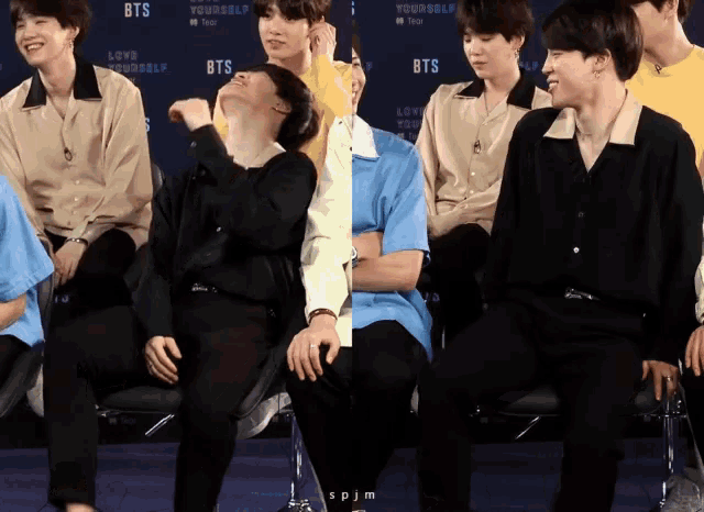 a group of boys are sitting in front of a wall that says bts