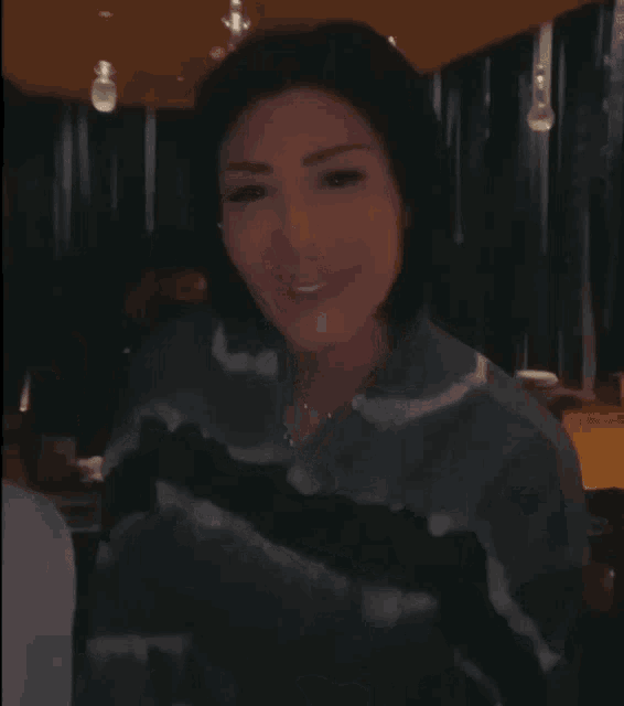 a woman in a tie dye sweater is smiling