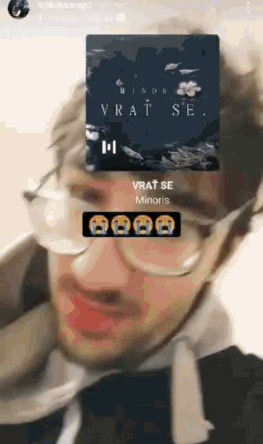 a man wearing glasses is looking at a screen that says vrat se minoris on it