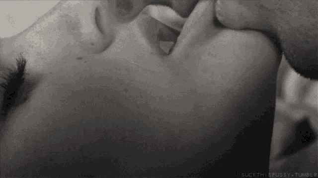 a black and white photo of a man and a woman kissing .