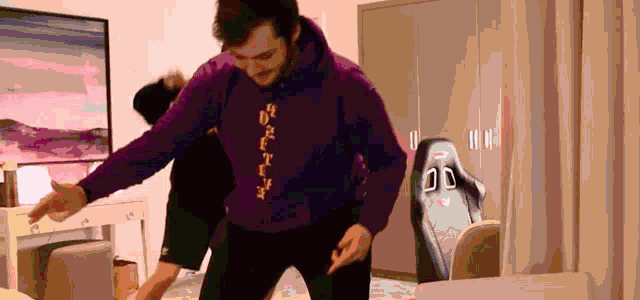 a man wearing a purple hoodie with chinese writing is dancing