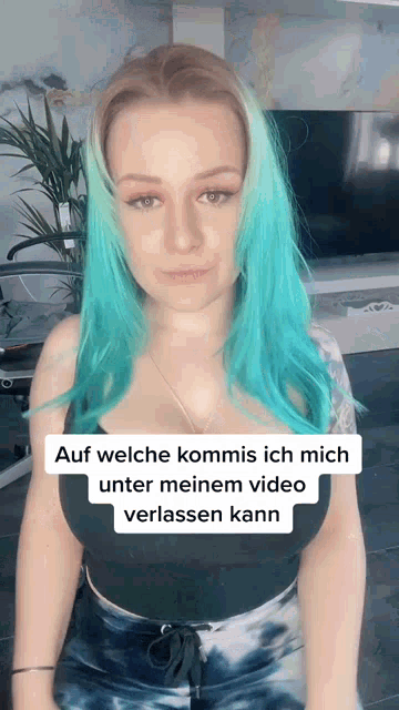 a woman with blue hair is wearing a black tank top
