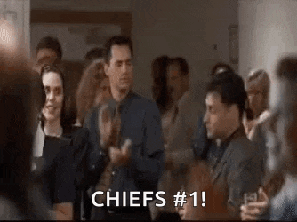 a group of people are clapping in a room and a man is saying `` chiefs # 1 '' .
