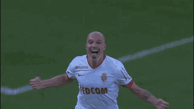 a soccer player wearing a shirt that says fedcom sticks out his tongue