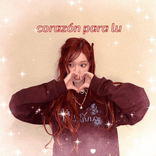 a girl with red hair making a heart with her hands and the words corazon para lu
