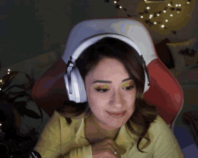 a woman wearing headphones is sitting in a chair