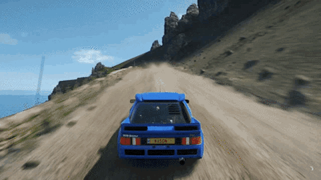 a blue car is driving down a dirt road and has a license plate that says r45 gx