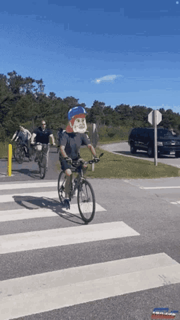 a man wearing a gorilla mask is riding a bicycle