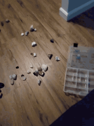a pile of rocks on the floor next to a plastic box