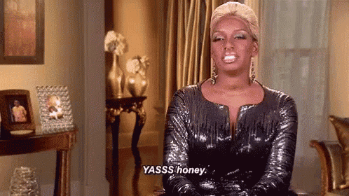a woman in a sequined dress is sitting in a living room and says yasss honey .