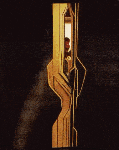 a man is standing in a doorway in a dark room .