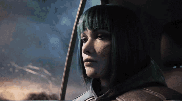 a woman with green hair is looking out the window of a car
