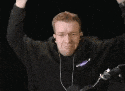 a man wearing headphones and a black hoodie with the word racing on the front