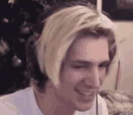 a man wearing headphones and a white shirt is smiling .