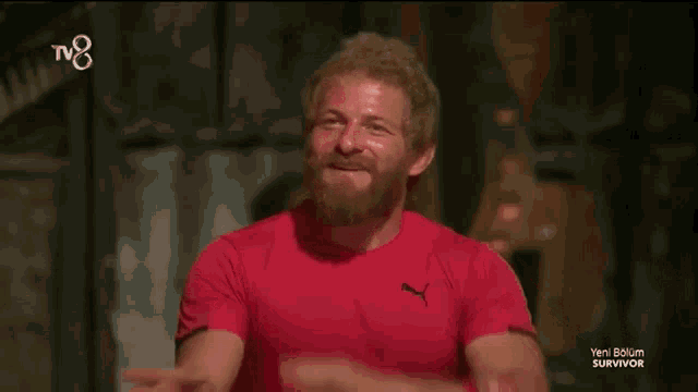 a man in a red shirt with the word survivor on the bottom left