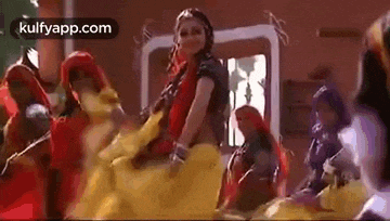 a woman is dancing in front of a group of people in a room .