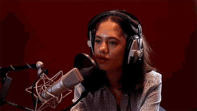 a woman is singing into a microphone with her eyes closed