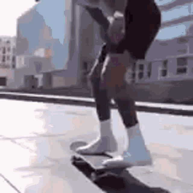 a person is riding a skateboard on a sidewalk with a building in the background .
