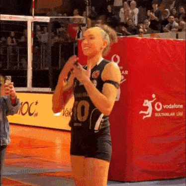 a female volleyball player wearing a number 10 jersey stands on a court