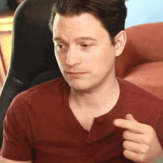 a man in a red shirt is pointing his finger at something