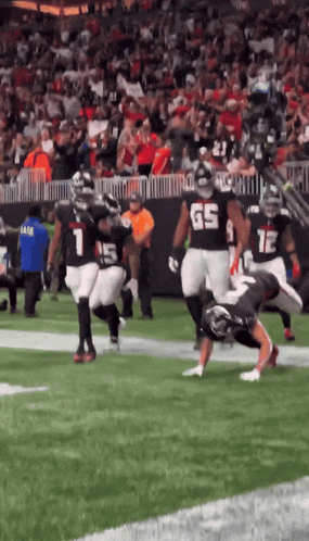 a football player with the number 65 on his jersey is being tackled
