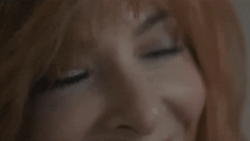 a close up of a woman 's face with a blurry background
