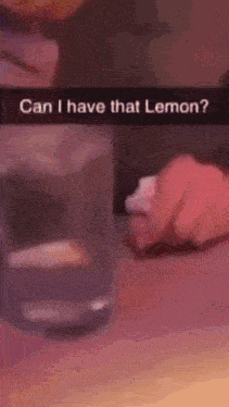 a person is holding a piece of paper next to a glass of water and asking if they have that lemon .