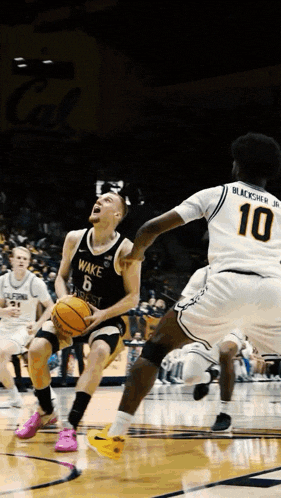 a wake basketball player dribbles the ball while another player tries to block him