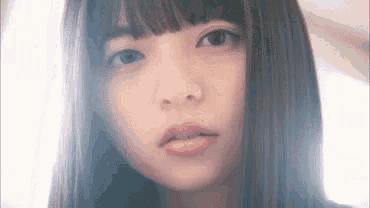 a close up of a woman 's face with long hair and a fringe .