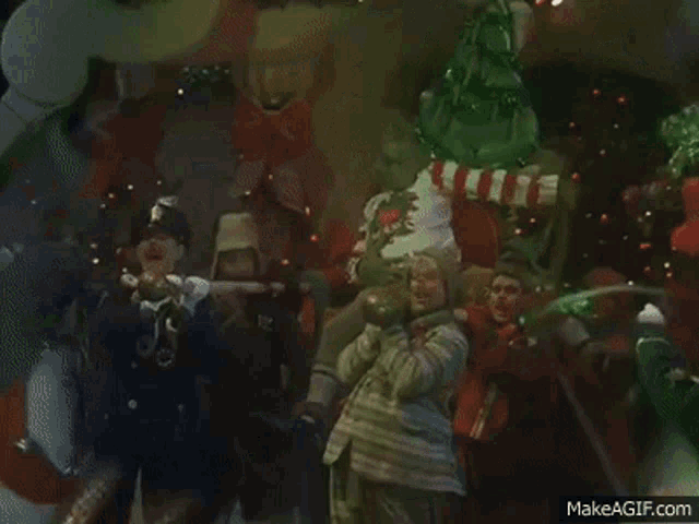a group of people are standing around a grinch who is holding a baby .