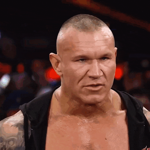 a man with a shaved head is wearing a black hoodie