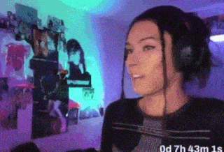 a woman wearing headphones is standing in front of a wall with pictures on it .