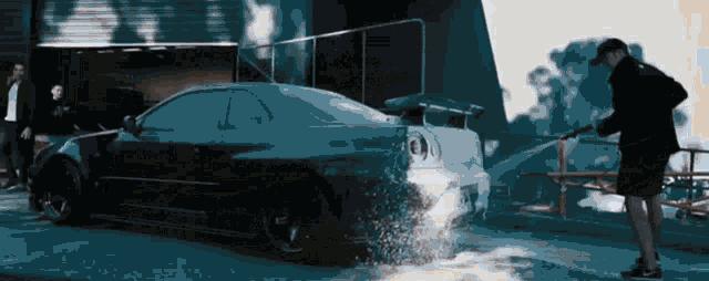 a man washes a car with a high pressure hose