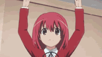 a girl with red hair is holding her hands up in the air .