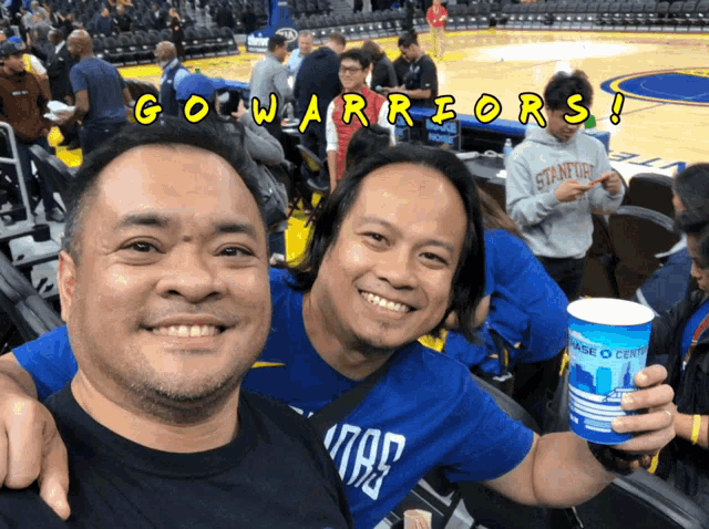 two men are posing for a picture with the words go warriors written in yellow
