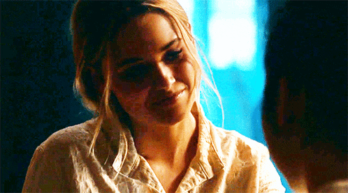 a woman in a white shirt is smiling at a man .