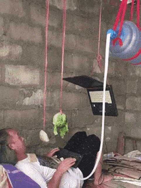 a man is laying on a bed with a laptop on his lap