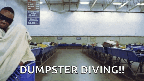a man is wrapped in a blanket in a room with the words dumpster diving written on the floor