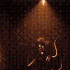a person is standing in a dark room with a yellow light shining on them